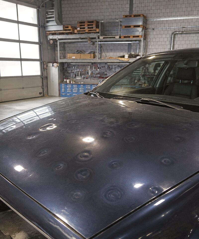 Hagelschaden auf der Motorhaube eines Autos